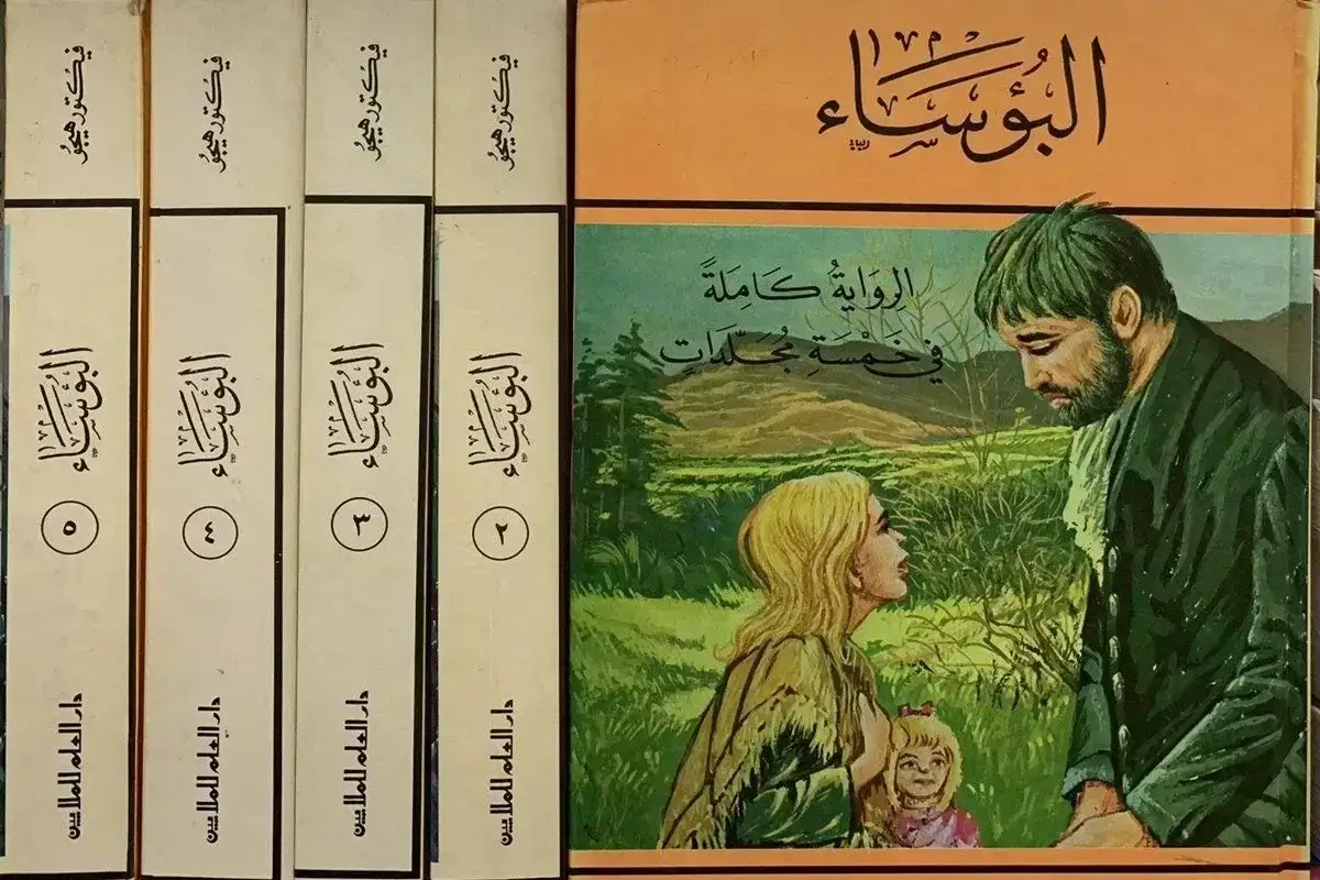 مجموعة من خمسة مجلدات لرواية "البؤساء" للكاتب الفرنسي فيكتور هوجو، تظهر أغلفة وأكعاب الكتب مع رسم توضيحي لشخصيات الرواية جان فالجان وكوزيت.