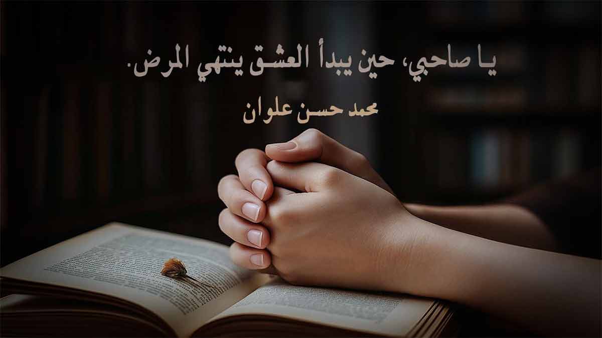 يدان متشابكتان فوق كتاب مفتوح يعرض اقتباس عن الحب والعشق للكاتب محمد حسن علوان، ضمن مقالة عن اقتباسات عن الحب من الكتب والروايات.